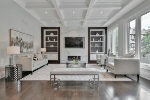A refined living room combines a streamlined sofa, carved wood table, layered textiles, and warm natural light.
