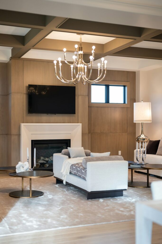 A refined living room with tailored seating, natural wood furniture, layered lighting, and textured fabrics.